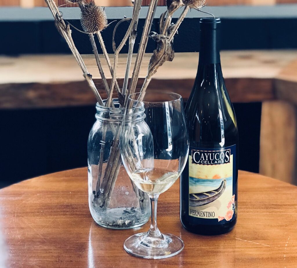 A bottle of wine and a glass on a table.