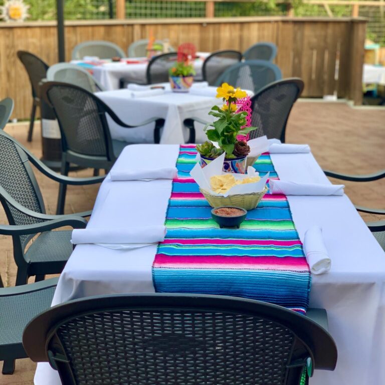 An outdoor patio with a colorful table runner.
